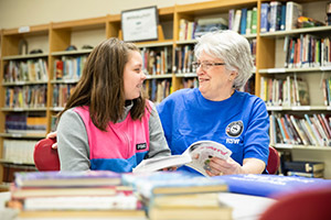 Foster Grandparent helping a child read